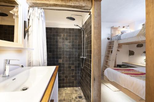 een badkamer met een douche, een wastafel en een bed bij El Pino Centenario 8 in La Orotava