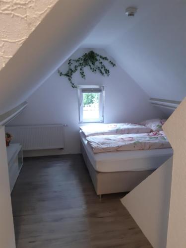 a bedroom with a bed and a window at Gästehaus - Café Frank in Antweiler