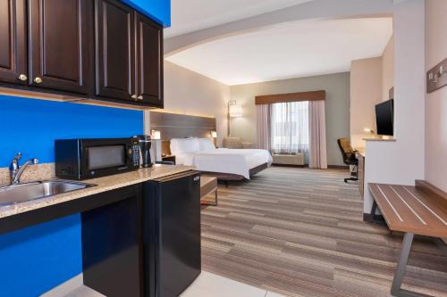 a hotel room with a bed and a kitchen at Holiday Inn Express Hotel & Suites Warminster-Horsham by IHG in Warminster