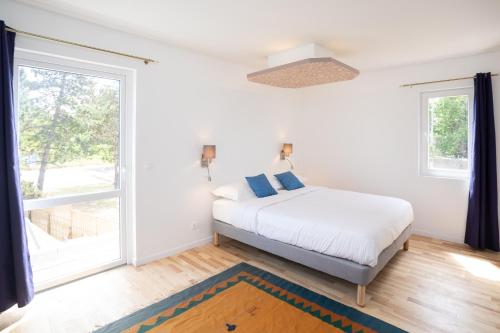 een slaapkamer met een bed en een groot raam bij Chambre d'hôtes des pins in Cayeux-sur-Mer