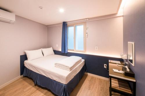 釜山MAMA Guesthouse Haeundae的小房间设有床和窗户