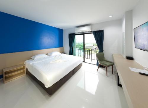 a bedroom with a bed with a blue accent wall at B Hotel in Khon Kaen