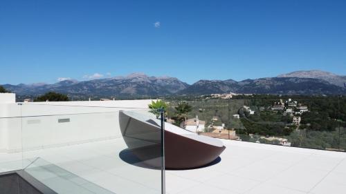 a bench on the roof of a building with mountains at Mont Blau in Búger