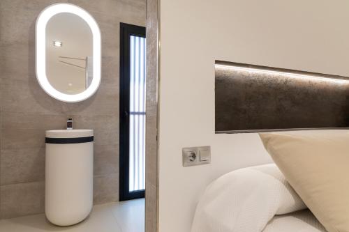 a bedroom with a white bed and a mirror at Mont Blau in Búger