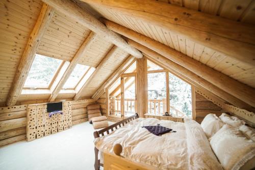 a bedroom in a log cabin with a bed at Cabane- Vila Crinul si Teodor Poiana Brasov in Poiana Brasov