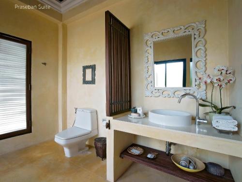 a bathroom with a sink and a toilet and a mirror at Praseban Resort in Pran Buri
