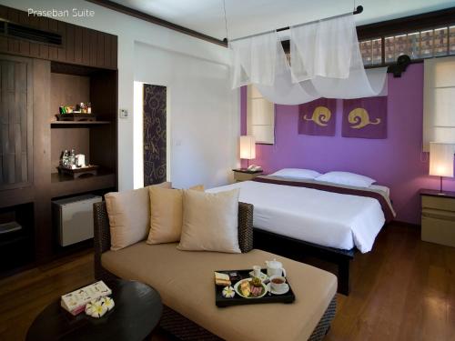a hotel room with a bed and a couch at Praseban Resort in Pran Buri