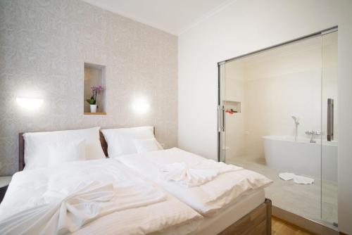 a bedroom with a large white bed and a bath tub at NA KNÍŽECÍ CESTĚ VALTICE in Valtice