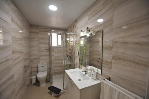 y baño con lavabo, aseo y espejo. en Centrico Playa Caleta 3 dormitorios, en Cádiz