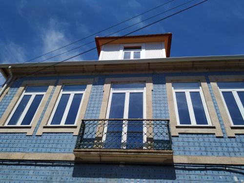 a blue building with windows and a balcony at Casa Archie in São Pedro do Sul