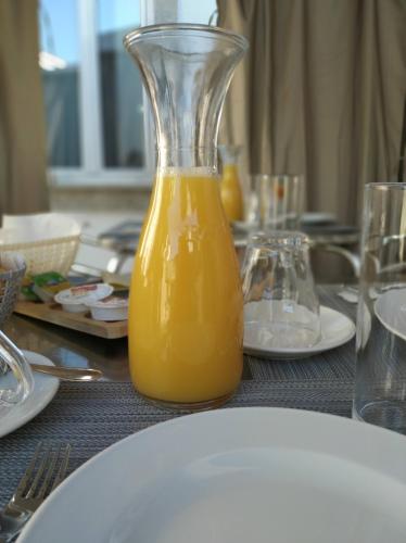 a glass vase filled with orange juice on a table at Casa Archie in São Pedro do Sul