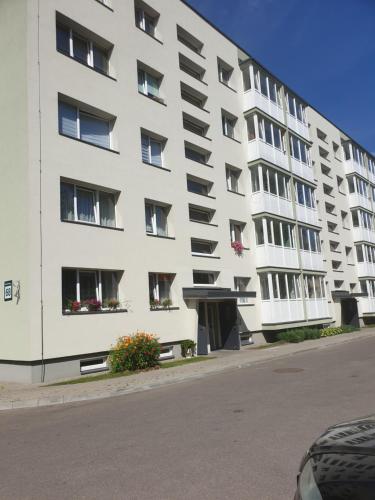 biały budynek mieszkalny z oknami na ulicy w obiekcie Lima C w Druskienikach