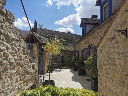 a courtyard of an old stone building with potted plants at Les Vieilles Pierres chambres d'hôtes in Ognon