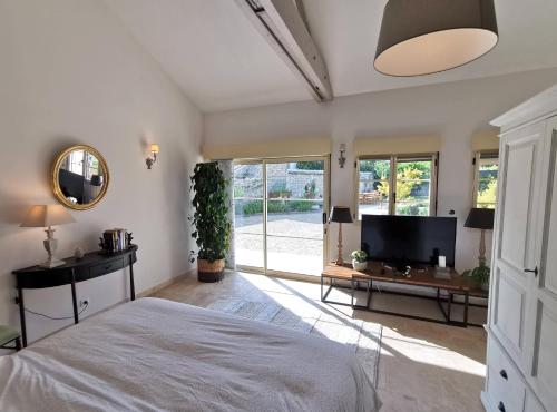 ein Schlafzimmer mit einem großen Bett und einem TV in der Unterkunft Les Vieilles Pierres chambres d'hôtes in Ognon