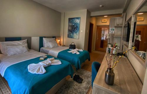 Montebay Perla في بريكانج: سريرين في غرفة الفندق عليها مناشف