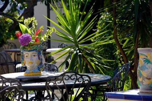 a table with a vase with a face on it at Hotel Oriente in Lipari