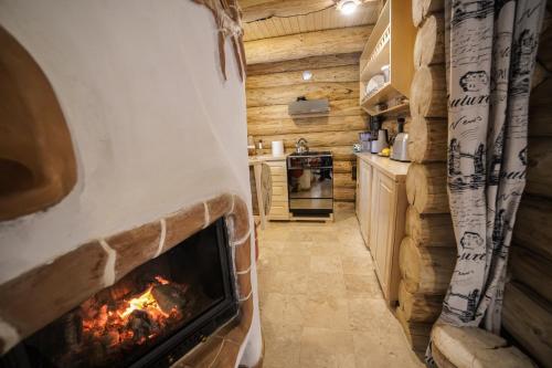 una chimenea en una cocina en una cabaña de madera en Cabane- Vila Crinul si Teodor Poiana Brasov en Poiana Brasov