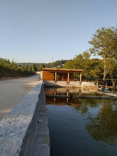 a building on the side of a road next to a river at Casa Archie in São Pedro do Sul