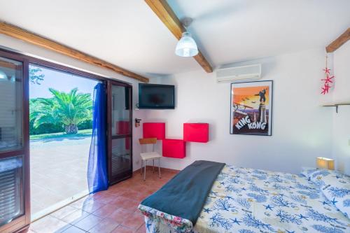 Schlafzimmer mit einem Bett und einer Glasschiebetür in der Unterkunft Bilocale in Villa Elba in Marina di Campo