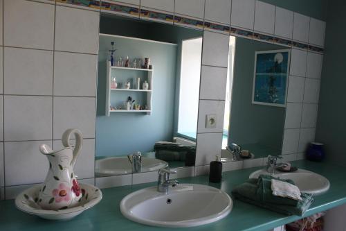 a bathroom with two sinks and a mirror at Zelda in Roôcourt-la-Côte