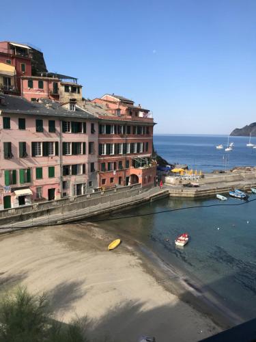 a beach with buildings and boats in the water at Candidina 2 in Vernazza