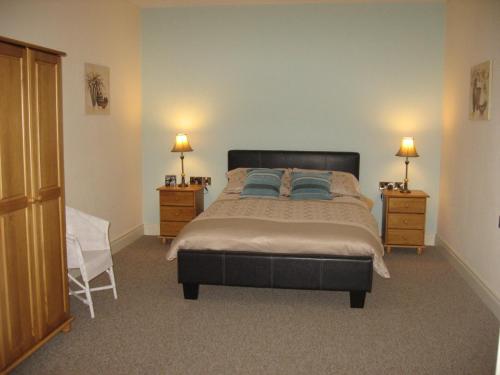 1 dormitorio con 1 cama grande y 2 mesitas de noche en Castle View Cottage, en Irvinestown