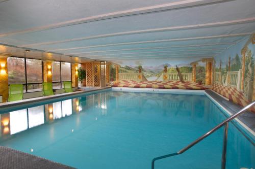 a large indoor swimming pool with a painting on the wall at Landhotel Seeg in Seeg