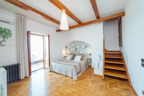 a bedroom with a bed and a wooden floor at Villa Carolina Sorrento Private Heated Pool and Sea View in Sorrento