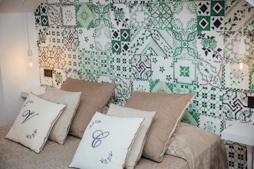 a room with a bed with pillows and a wallpaper at Villa Carolina Sorrento Private Heated Pool and Sea View in Sorrento