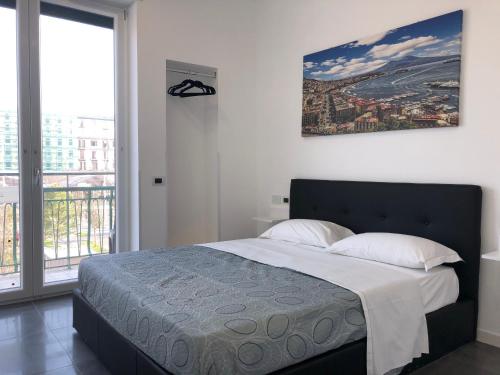 a bedroom with a bed and a large window at Top Floor Rentrooms Napoli in Naples