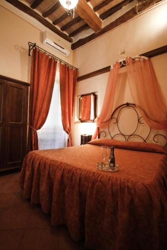 a bedroom with a bed with a red blanket and a window at Antica Residenza Cicogna in Siena