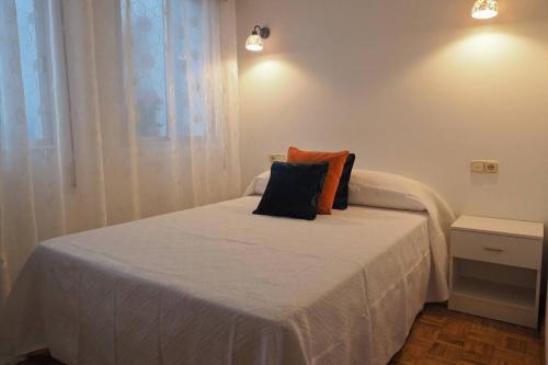 a bedroom with a bed with two pillows on it at Apartamento El Parque in Padrón
