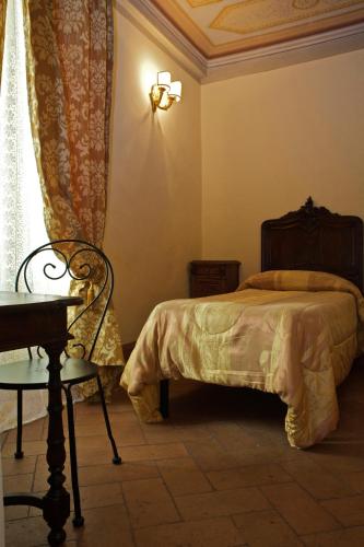 a bedroom with a bed and a table and a chair at Antica Residenza Cicogna in Siena