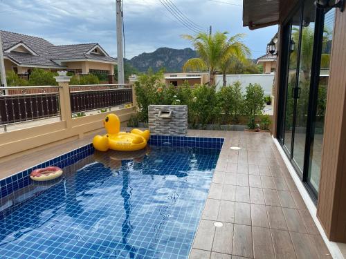 uma piscina com um pato de borracha na água em บ้านฟูจิ (Fuji House Cha-Am) em Ban Bo Prakhon