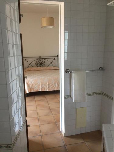 ein Bad mit einem Bett in einem Zimmer mit einer Dusche in der Unterkunft VelaLatina Residence B&B Soverato - Camera Scirocco in Soverato Marina