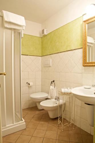 a bathroom with a sink and a toilet and a mirror at Antica Residenza Cicogna in Siena