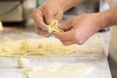 a chef is kneading dough with an egg on a table at Langtaufererhof in Melago