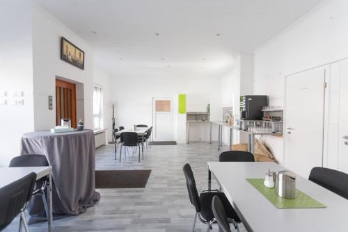 um quarto branco com mesas e cadeiras e uma cozinha em Oberkasseler Hof Bonn em Bona