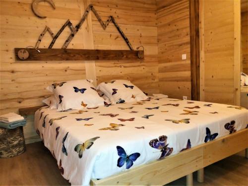 a bedroom with a bed with butterflies on it at Appartement 2 pièces cuisine Les Hermines in Saint-Nicolas-la-Chapelle
