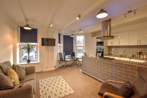 a living room with a couch and a kitchen at The Place by the Sea in Blackpool