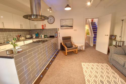 a kitchen and living room with a counter and a couch at The Place by the Sea in Blackpool
