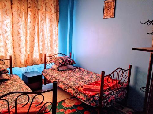 - une chambre avec 2 lits et 2 chaises dans l'établissement Salam D'Mawar Homestay, à Sungai Coh