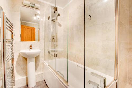 uma casa de banho com um chuveiro, um lavatório e um WC. em Greaves Wharf House em Porthmadog