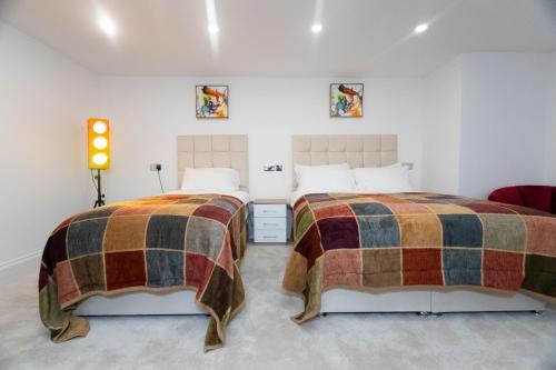 Westwood Apartment في ليدز: سريرين يجلسون بجانب بعض في غرفة النوم