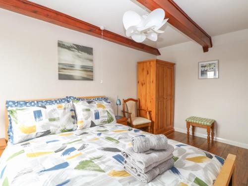 a bedroom with a bed and a ceiling fan at Compass Cottage in Holt