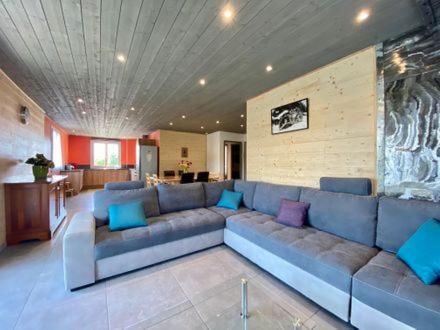 a living room with a large blue couch with pillows at Gîte La Camarine - Les Estables - 8 places in Les Estables