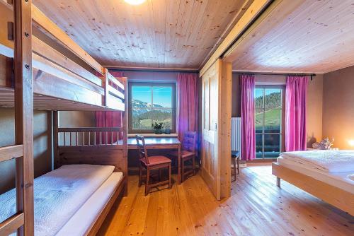 - une chambre avec des lits superposés, une table et un bureau dans l'établissement Leitnhof, à Reith im Alpbachtal