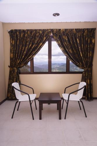two chairs and a table in front of a window at Sunrise Kundasang Resort in Ranau