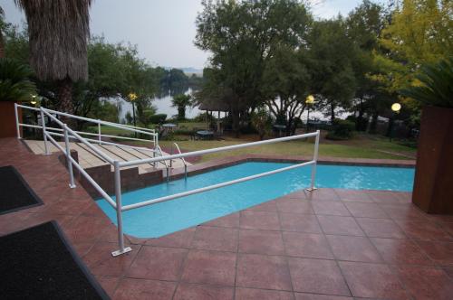 瓦爾威的住宿－海濱鄉村山林小屋，游泳池旁边设有金属栏杆
