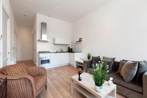 a living room with a couch and a table at Comfortable central apartment with private balcony in Amsterdam